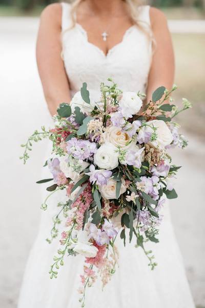 Cascading bridal bouquet featuring lavender stock, pink larkspur, champagne roses, white ranunculus, pink astilbe, eucalyptus |  Pastel bridal bouquet 