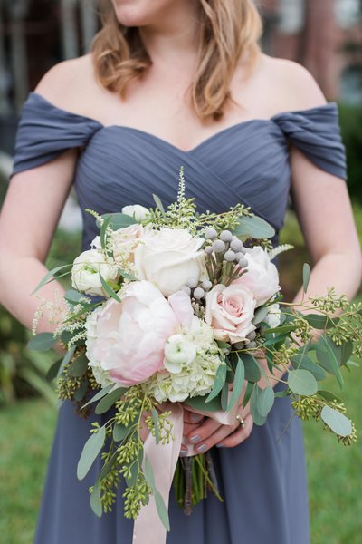 Slate blue bridesmaid dress | Hand tied bridesmaid bouquet with blush peonies, garden roses, champagne roses, silver brunia, ranunculus, astilbe and a variety of eucalyptus